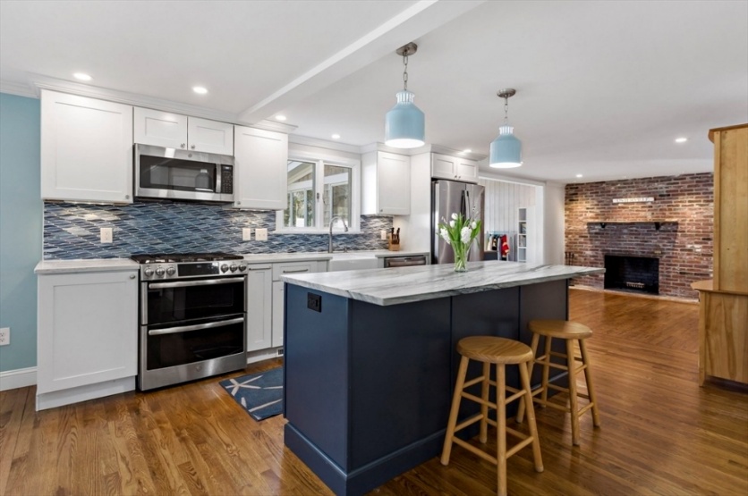 Chef's kitchen with navy blue island and quartz countertops